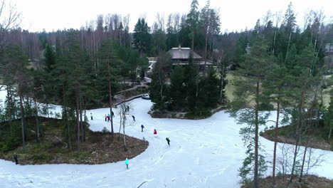 Skating-in-a-park-along-flooded,-frozen-walkways-or-a-pond-or-river---ascending-aerial-view