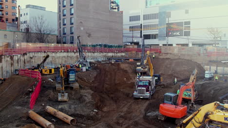 Digger-excavators-dig-dirt-into-truck-in-inner-city-jobsite-during-the-morning