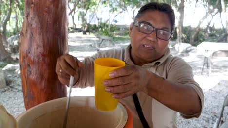 Una-Mujer-Indígena-Maya-Vendiendo-Atole-De-Chocolate-Champurrado-Al-Cliente