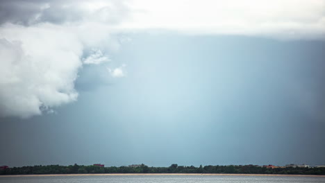 Static-shot-of-rain-clouds-movement-after-rainfall-with-rainbow-fading-away-in-timelapse-at-daytime