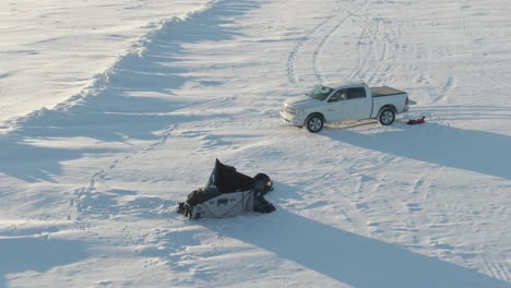 2-Mujeres-Instalando-Un-Refugio-De-Carpa-En-La-Nieve,-Lago-Congelado,-Drone