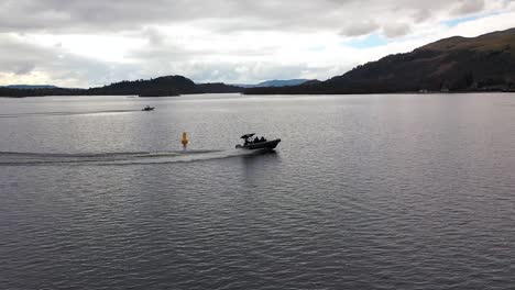 Cinematic-Aerial-Slow-Mo-Drone-Shot-Of-Boats-Cruising-And-Making-Turns-On-Loch-Lomond-Scotland-From-Low-Angle-In-Early-Spring