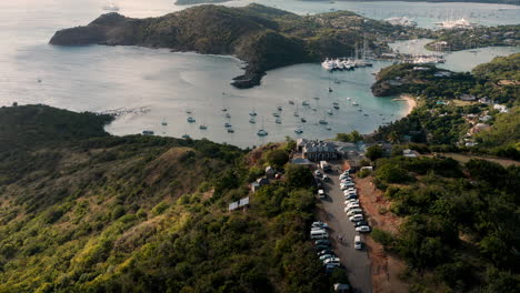 Sunny-aerial-shot-of-English-Harbor-in-Antigua,-Caribbean-with-views-of-yachts,-sailboats,-marina,-bay-and-cliffs