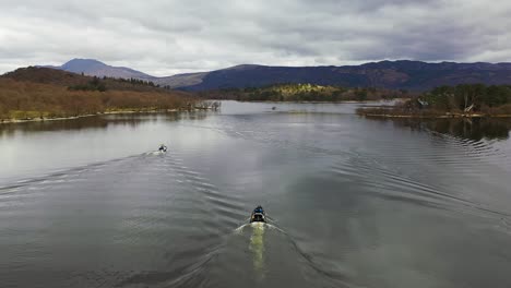 Cinematic-aerial-angle-of-drone-flyby-following-three-boats-approaching-the-narrows-on-Loch-Lomond-in-Scotland