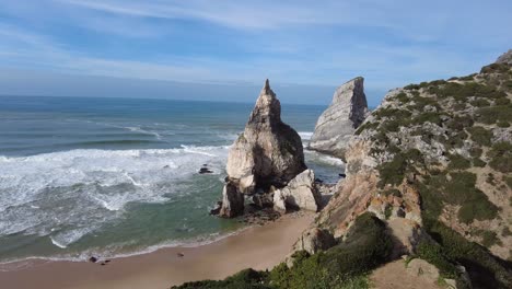 Panning-across-Praia-da-Ursa-beach-and-cliffs-with-rough-seas