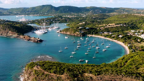 Sonnige-Luftaufnahme-Des-Englischen-Hafens-In-Antigua,-Karibik-Mit-Blick-Auf-Yachten,-Segelboote,-Marina,-Bucht-Und-Klippen
