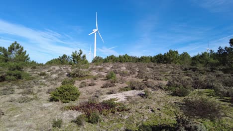 Two-wind-turbines-spinning-quickly-on-sunny-day-with-blue-skies-in-Portugal
