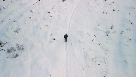 Drone-Filmando-A-Un-Hombre-Caminando-Por-Un-Sendero-En-La-Nieve