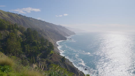 Time-Lapse-shot-of-mountainside-view-of-Pacific-ocean-with-waves-crashing-along-the-beach-located-in-Big-Sur-California