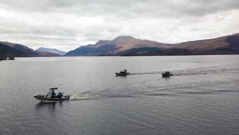 Filmische-Drohnenaufnahme-Aus-Der-Luft,-Die-Im-Frühjahr-Um-3-Boote-Herumfegt,-Die-Auf-Loch-Lomond-In-Schottland-Fahren,-Mit-Ben-Lomond-Im-Hintergrund