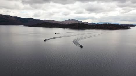 Filmische-Luftaufnahmen-Von-Hohem-Bis-Niedrigem-Drohnenwinkel-Von-3-Booten,-Die-Im-Frühjahr-Auf-Loch-Lomond-Fahren-Und-Schnelle-Kurven-Fahren