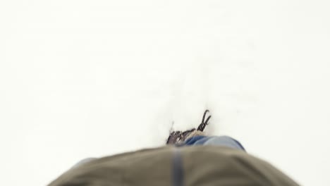 Close-up-of-a-person's-feet-walking-in-the-snow-in-slow-motion