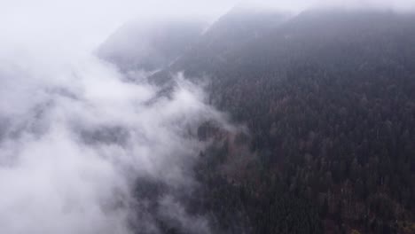 Luftaufnahme-Eines-Dunklen-Bergtals-Mit-Sich-Bewegenden-Wolken-Während-Des-Herbstfalls-In-Den-Vogesen,-Frankreich,-4k