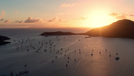 Aerial-shot-of-sunset-in-English-Harbor-in-Antigua,-Caribbean-with-views-of-yachts,-sailboats,-marina,-bay-and-cliffs