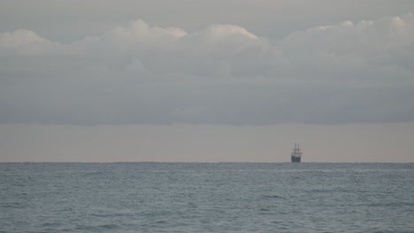 16th-Century-Galleon-Andalucia-replica-ship-sailing-in-the-distance-in-the-Mediterranean-sea-in-a-cloudy-day-at-sunrise