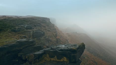 Aerial-Beautiful-steep-cliffs-shrouded-in-thick-slow-moving-mist