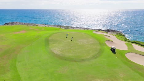 Aerial-arc-around-green-with-two-golf-players---Corales-Golf-Course-at-Puntacana