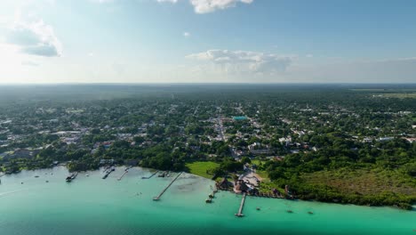 Aerial-view-away-from-the-Bacalar-village,-in-sunny-Mexico---pull-back,-drone-shot