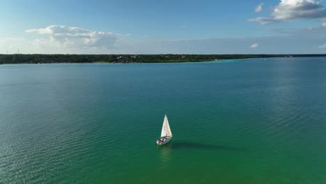 Aerial-view-around-a-sailling-boat-at-the-Laguna-Bacalar,-sunny-Quintana-roo,-Mexico---orbit,-drone-shot