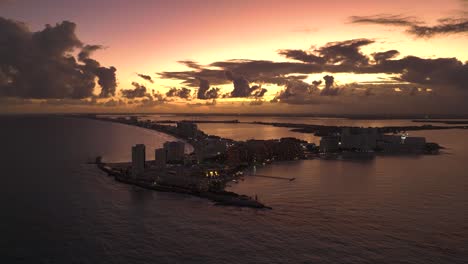 Aerial-view-around-the-Zona-hotelera,-moody-sunset-in-Cancun,-Mexico---wide,-panoramic,-drone-shot