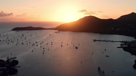 Aerial-shot-of-sunset-in-English-Harbor-in-Antigua,-Caribbean-with-views-of-yachts,-sailboats,-marina,-bay-and-cliffs