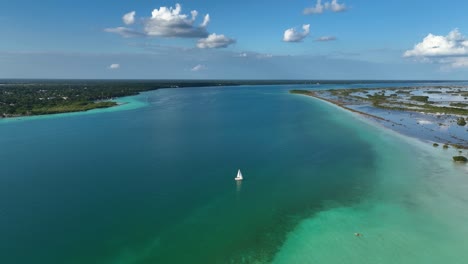 Aerial-view-of-a-sailboat-at-the-Bacalar-lagoon,-sunny-Quintana-roo,-Mexico