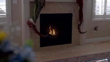 Christmas-stocking-hanging-beside-the-fireplace-then-rack-focus-to-the-bouquet-of-flowers-in-the-foreground---parallax-motion