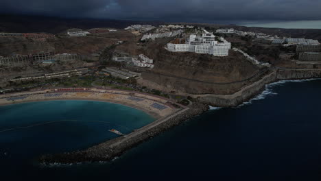 fantastic-aerial-shot-in-orbit-of-the-Amadores-beach-and-the-big-hotels-in-the-area,-during-sunset-on-the-island-of-Gran-Canaria