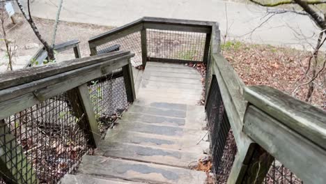 Hombre-Caminando-A-Cámara-Lenta-Por-Una-Escalera-De-Madera-En-Un-Parque-De-Estados-Unidos-Cove-Spring-Frankfort-Kentucky-4k
