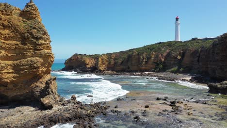Aireys-Inlet-vertical-aerial-of-lighthouse,-waves-and-cliffs,-Great-Ocean-Road,-Victoria,-Australia