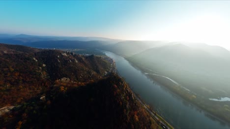FPV-flying-over-the-top-of-Danube-hills,-capturing-winter-mist-and-sun