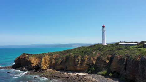 Aireys-Inlet-fly-over-aerial-of-lighthouse,-cliffs-and-beach,-Great-Ocean-Road,-Victoria,-Australia
