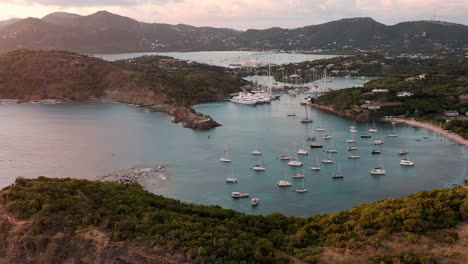 Luftaufnahme-Des-Sonnenuntergangs-Im-Englischen-Hafen-In-Antigua,-Karibik-Mit-Blick-Auf-Yachten,-Segelboote,-Jachthafen,-Bucht-Und-Klippen