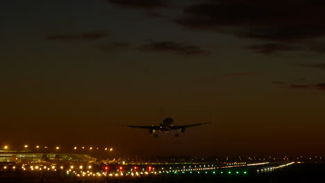Barcelona-airport-runway-illuminated,-plane-landing-early-evening