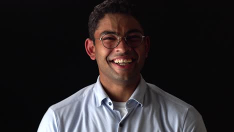 Portrait-Of-Mixed-Race-Man-Laughing-Out-Loud,-Isolated-In-Black-Background
