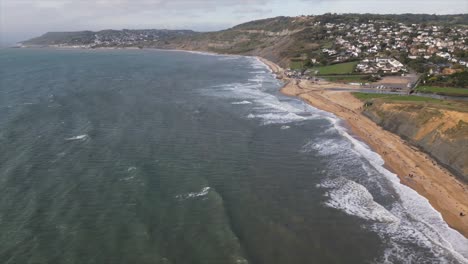 aerial-view-in-the-south-of-england,-dorset,-seashore-with-waves-and-foam
