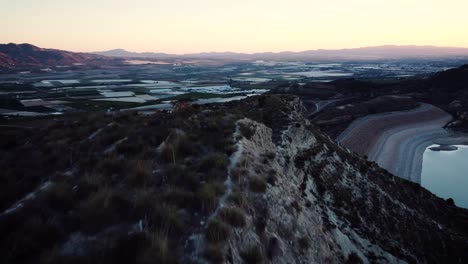 Sunset-over-the-mountain-range-in-the-region-of-Murcia-and-its-water-reservoir,-Spain