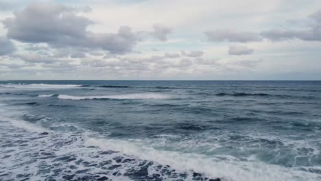 Ozeanhintergrund,-Hellblauer-Himmel-Mit-Weißen-Wolken-Und-Wellen-Am-Offenen-Meer,-Der-Sich-Dem-Horizont-Nähert