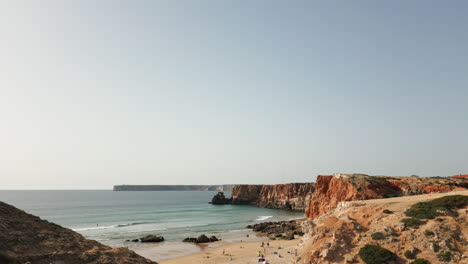 Low-flying-drone-shot-away-from-beach-at-Sagres-Portugal