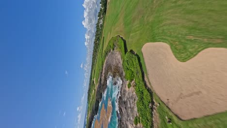 Drone-flying-over-Corales-Golf-Course-along-coastline,-Puntacana-Resort-and-Club,-Dominican-Republic