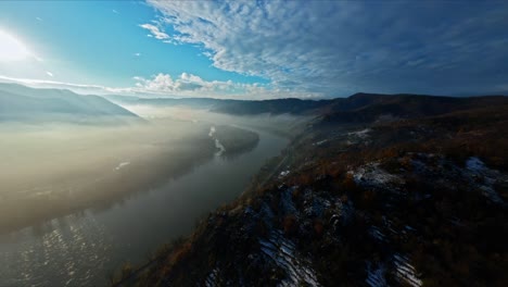 Slow-ascending-aerial-landscape-shot-of-misty-Danube-valley-during-calm-winter-time