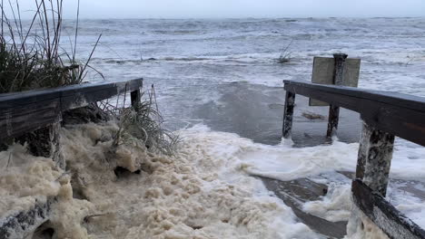 Storm-surge-and-sea-foam-cover-beach-walkway-from-Hurricane-Nicole-in-Florida