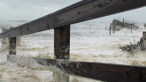 Florida-hurricane-waves-and-surge-flood-beach-dunes,-walkway-and-destroy-fence