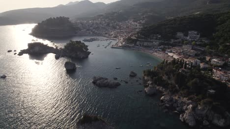 Cinematic-Aerial-View-Of-Parga-Coastline-And-Town-With-Sunshine-Reflected-In-The-Ionian-Sea