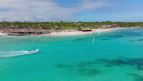 Boat-cruise-along-Caribbean-coastline---sandy-beach,-palms,-turquoise-sea,-Playa-Blanca-in-Punta-Cana