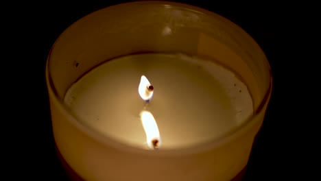 Close-up-shot-of-burning-flame-of-scented-wax-in-dark-background