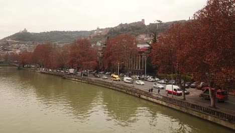 walking-along-river-during-autumn,-watching-colorful-trees,-collecting-colorful-leaves,-drinking-hot-local-drink,-indoor-activities-with-best-view-to-the-city