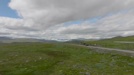 Single-road-passing-through-Hardangervidda-national-park-in-Norway,-aerial