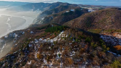 Fpv-überholschuss-Auf-Leicht-Verschneiten-Wald-Der-Wachau-Gefolgt-Von-Einem-Abenteuerlichen-Abstiegsschuss-In-Nebelschwaden
