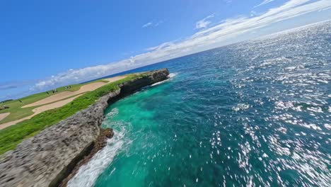 Aerial-speed-flight-along-coastline-of-Punta-Cana-with-crystal-clear-blue-water-near-Golf-Course-in-sunlight
